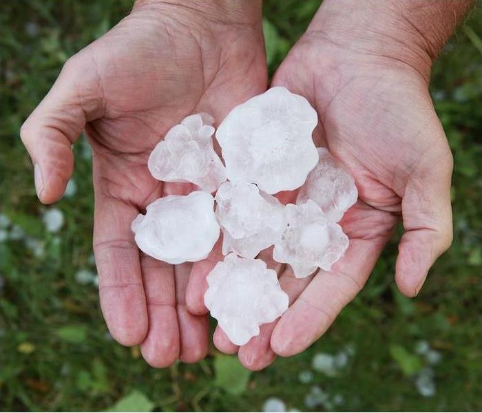 2 hands holding rocks of hail