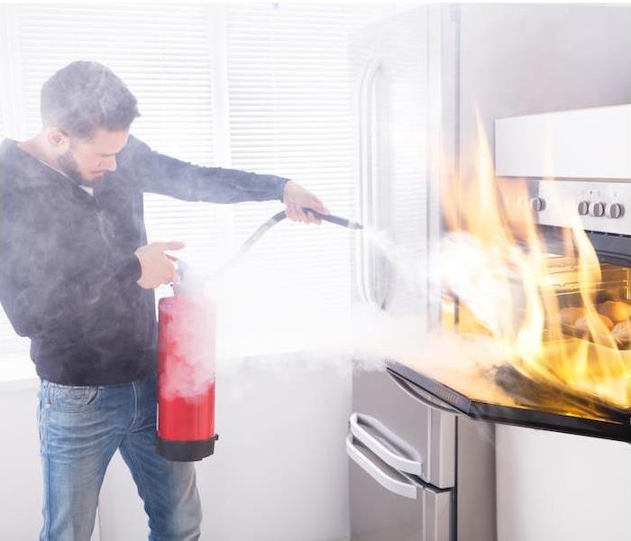man putting out a fire with a fire extinguisher