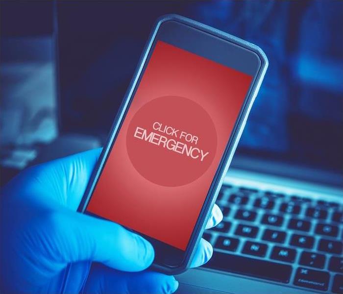 cell phone over a computer clicking for an emergency